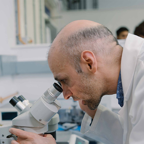 A chemist using a microscope.